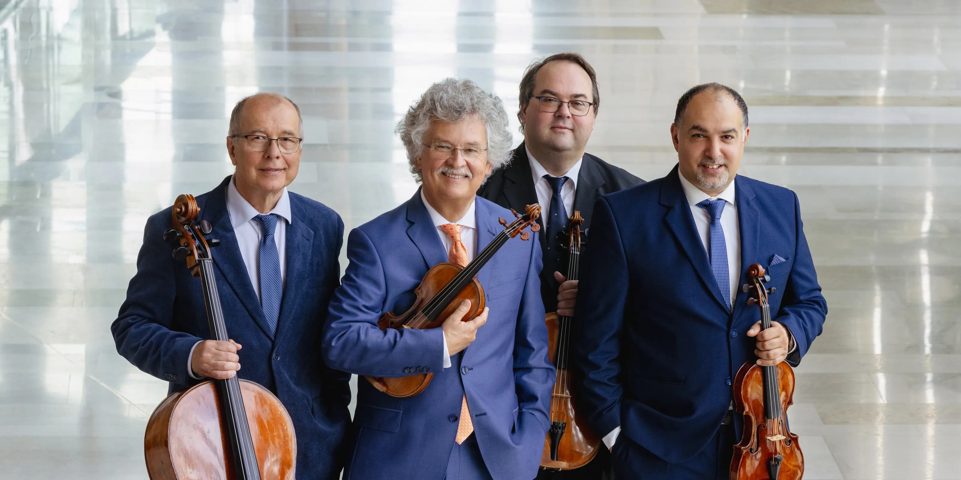 Kodaly Quartett Gruppenfoto in blauem Anzug und mit Instrumenten